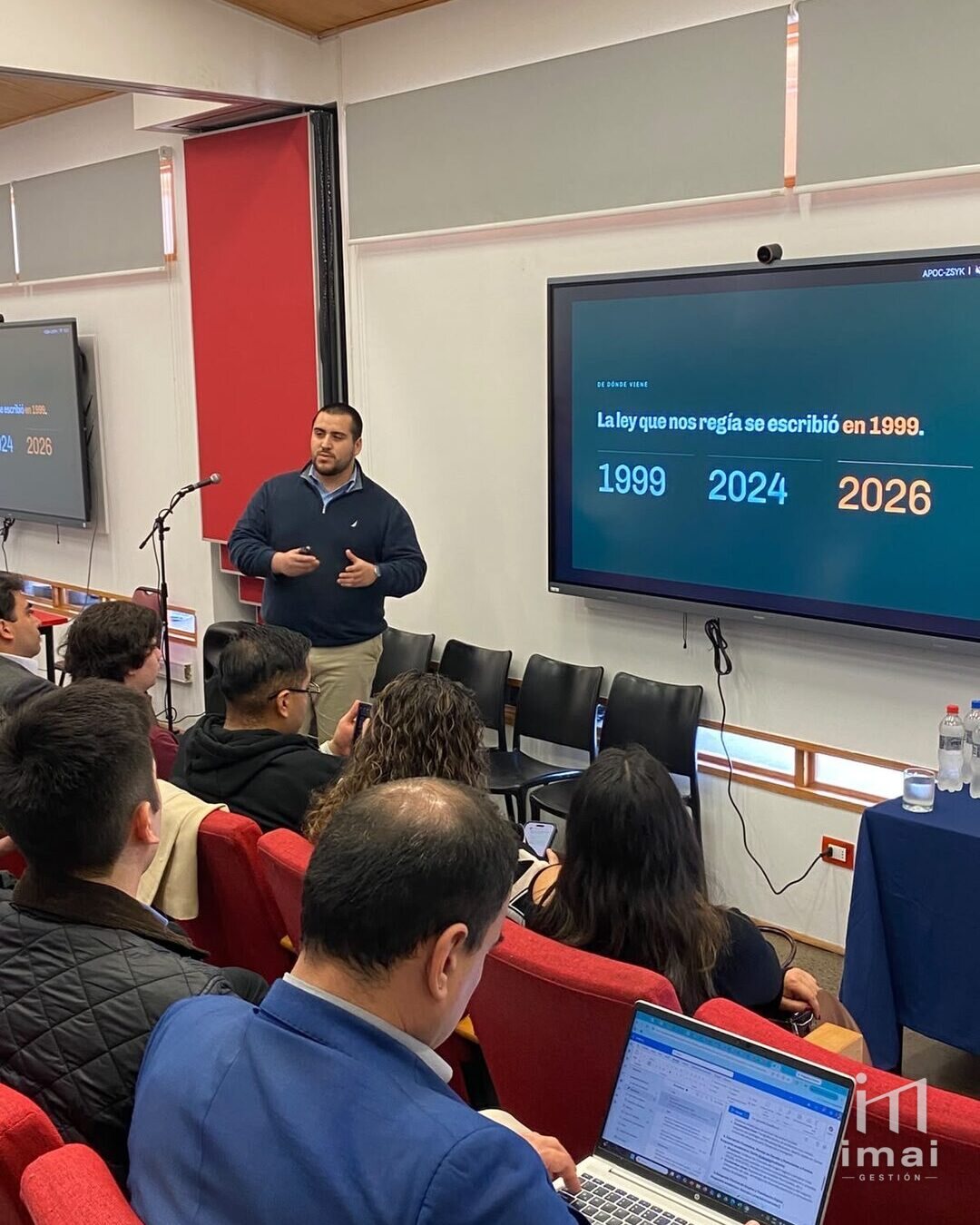 Sebastián Méndez presenta ante los asistentes del seminario, junto a una pantalla con la diapositiva «La ley que nos regía se escribió en 1999»